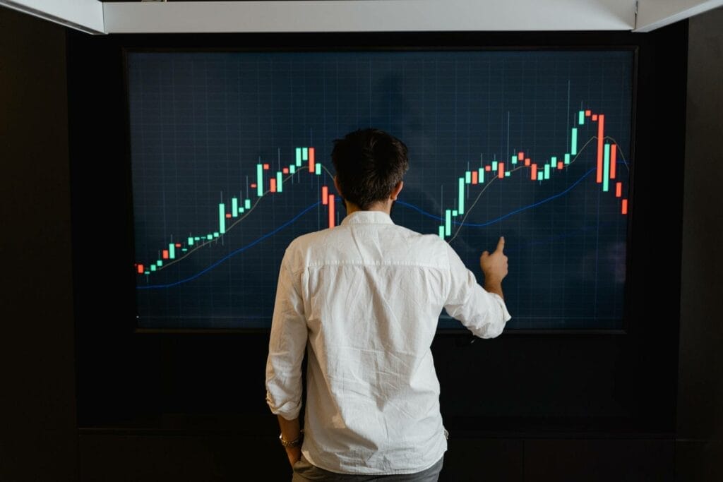A man facing a huge screen showing volatile Cryptocurrencies in the Market