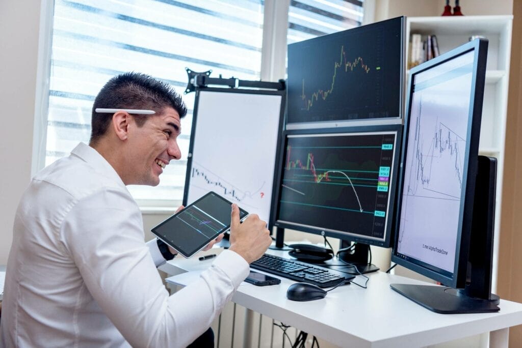 a person expressing happiness looking at a crypto stock graph on a computer monitor